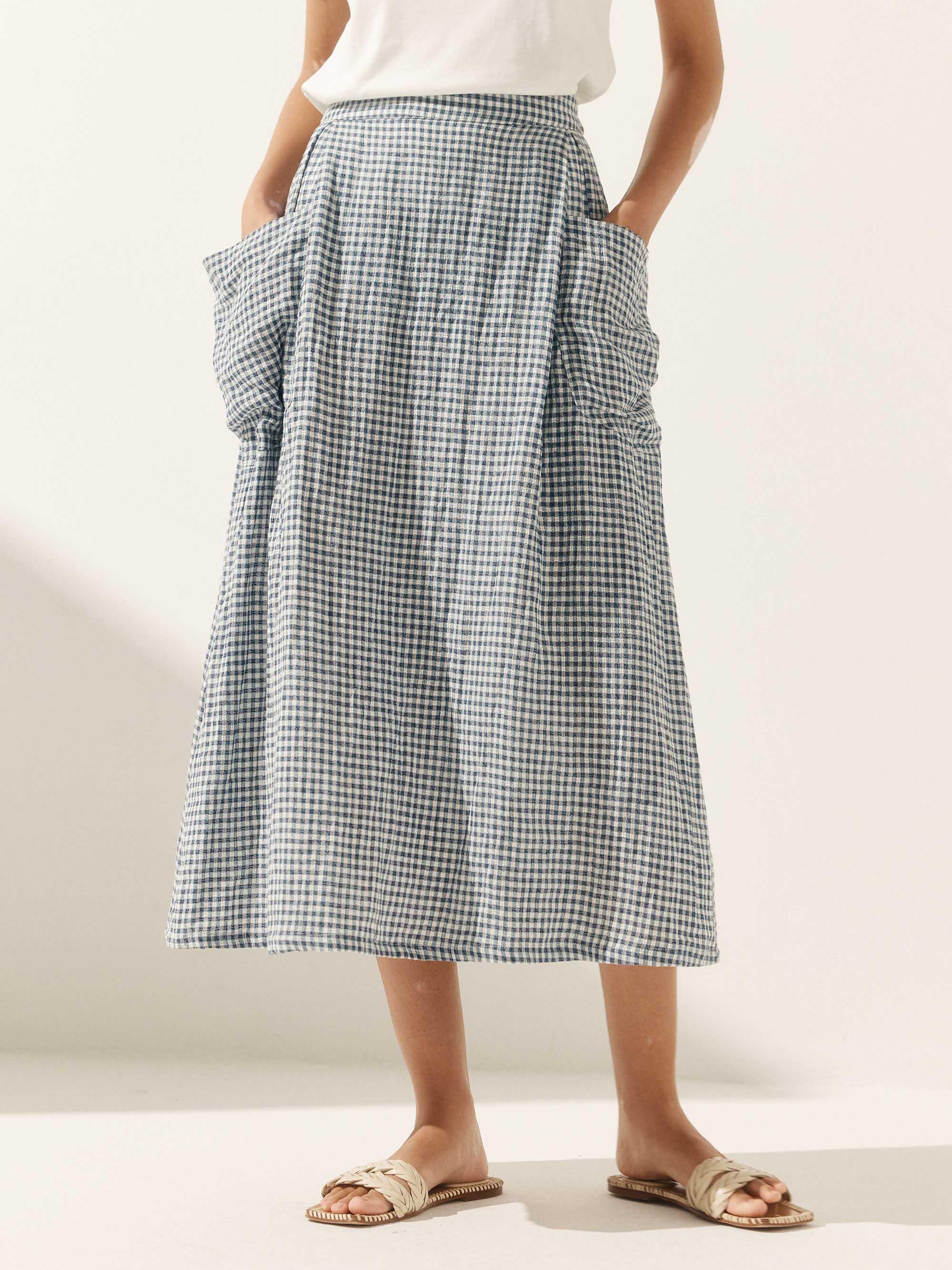 Person wearing a checkered skirt on a plain background