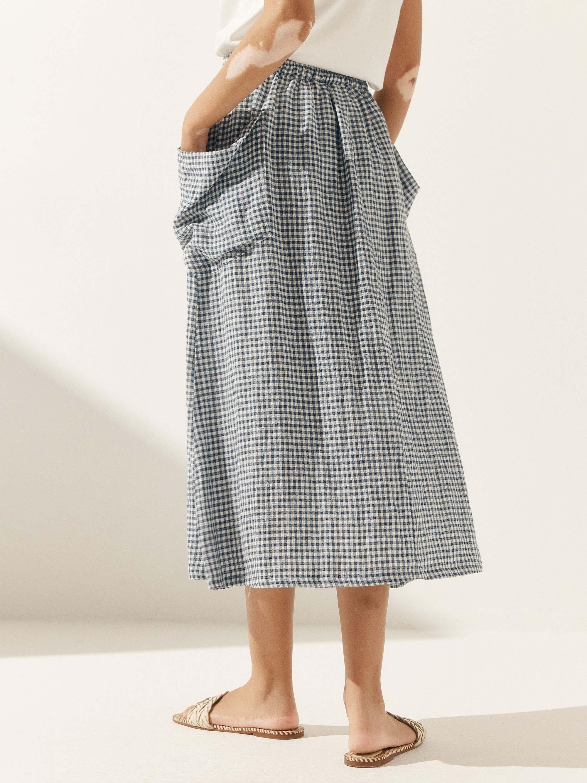 Person wearing a checkered skirt on a plain background