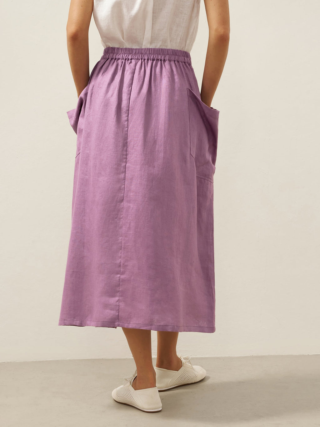Person wearing a purple skirt with a plain background