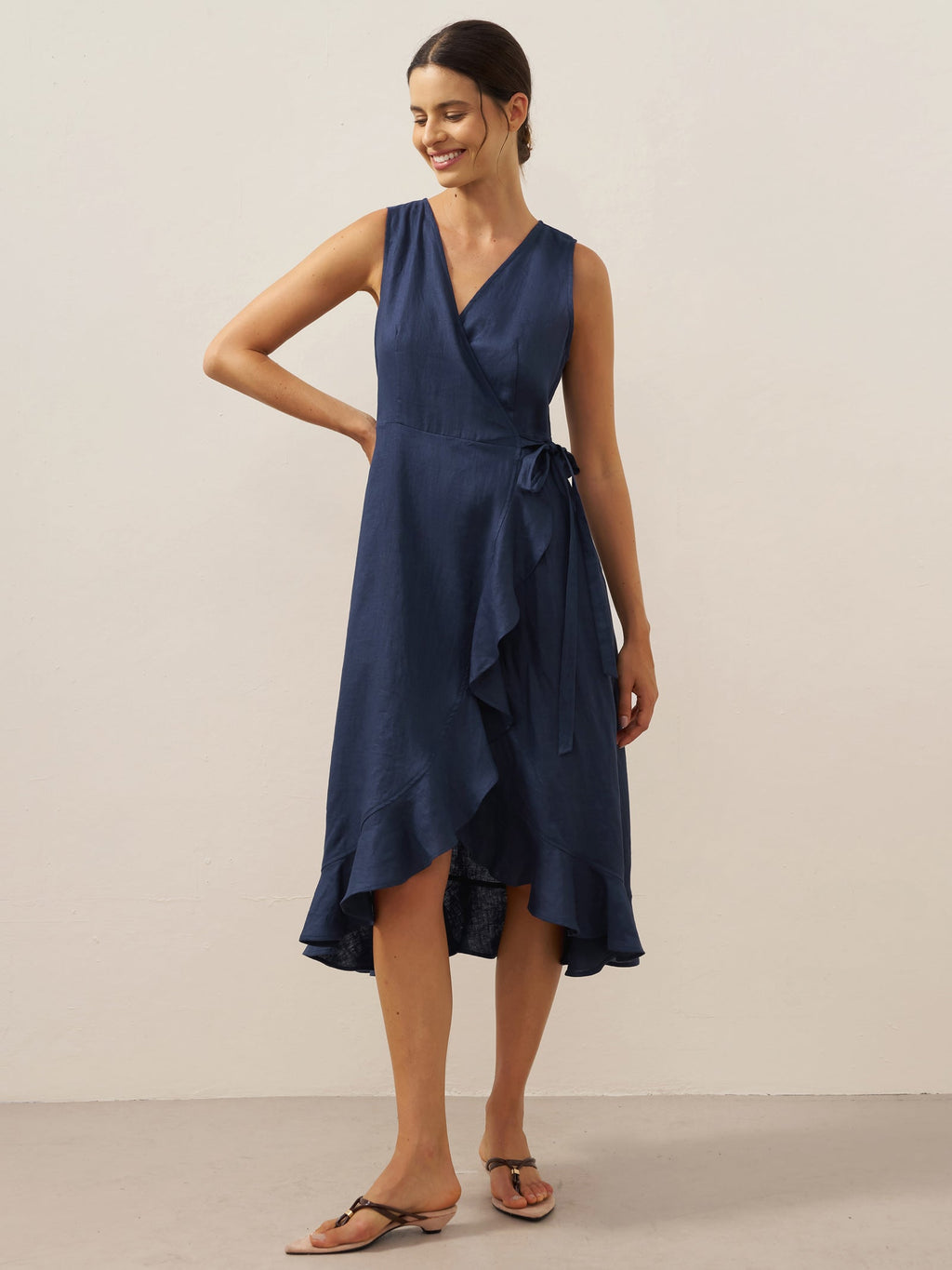 Woman wearing a navy blue dress against a plain background