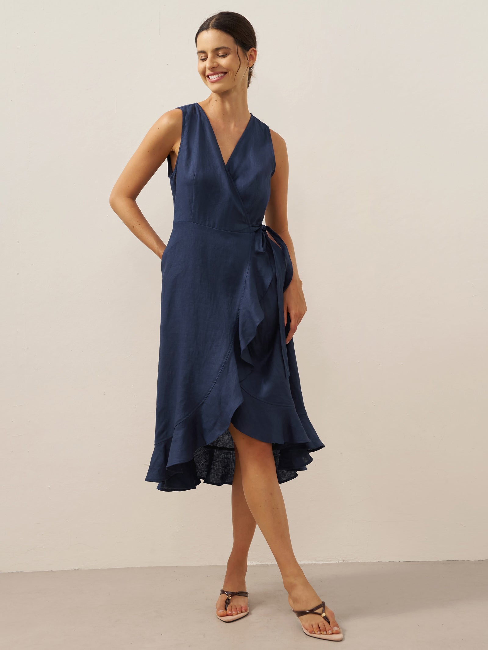 Woman wearing a navy blue dress against a plain background