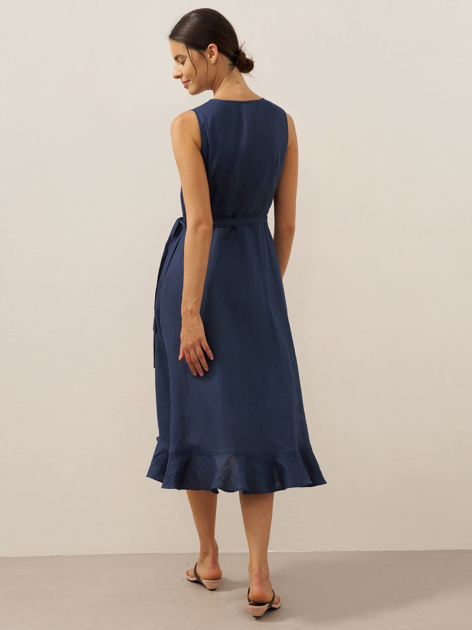 Woman wearing a navy blue dress against a plain background