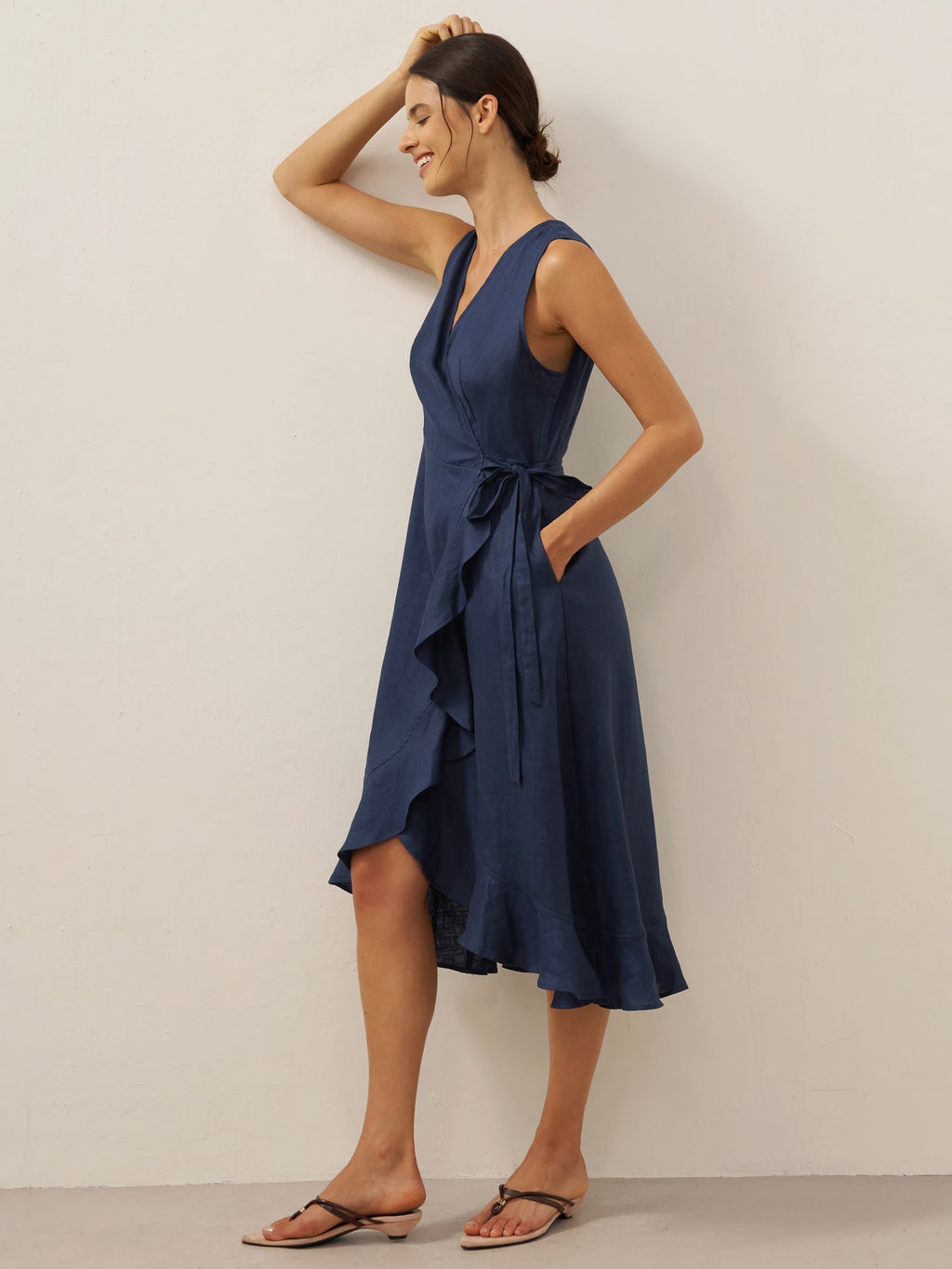 Woman wearing a navy blue dress against a plain background