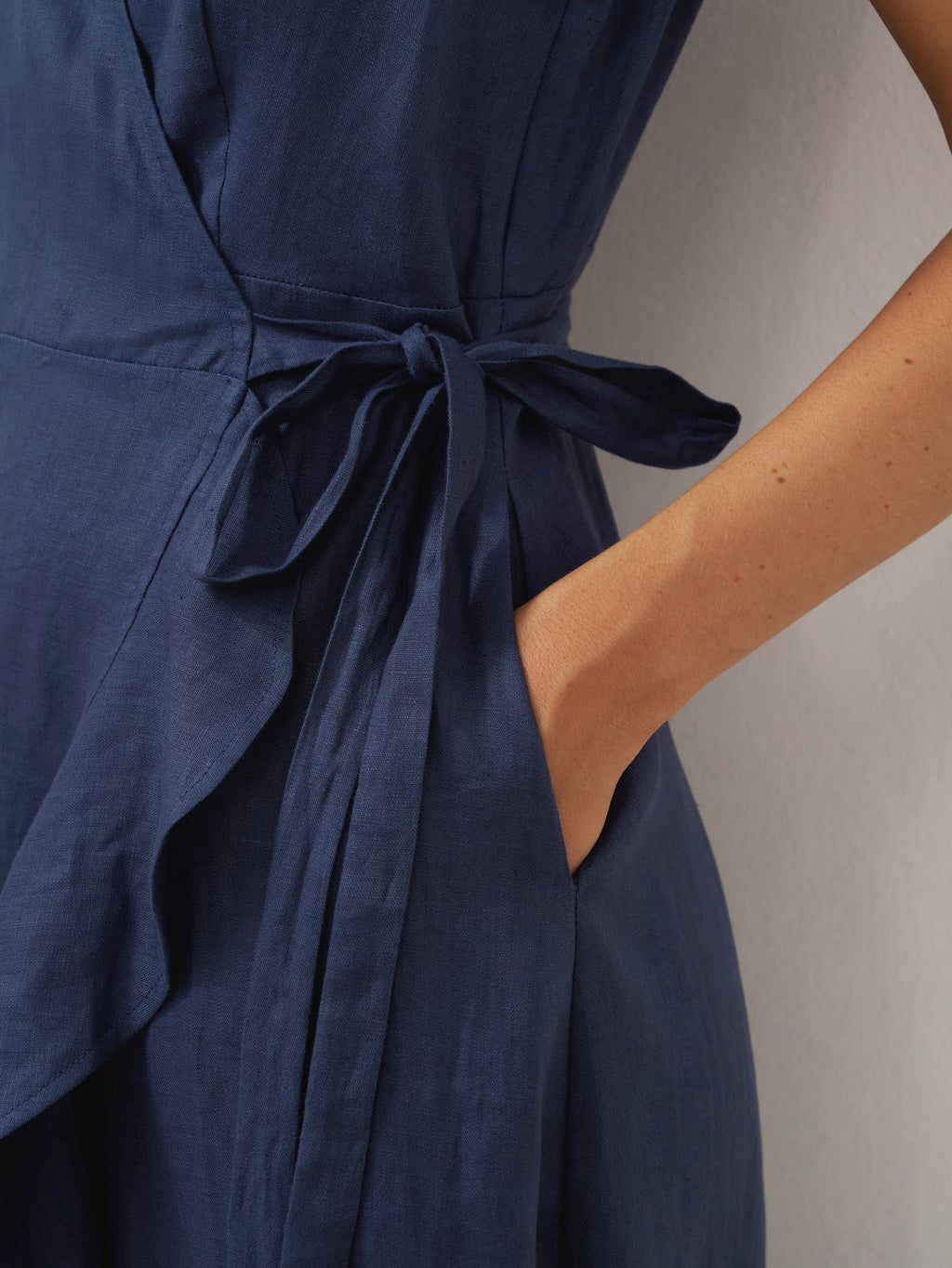 Navy blue dress with a tie waist on a neutral background
