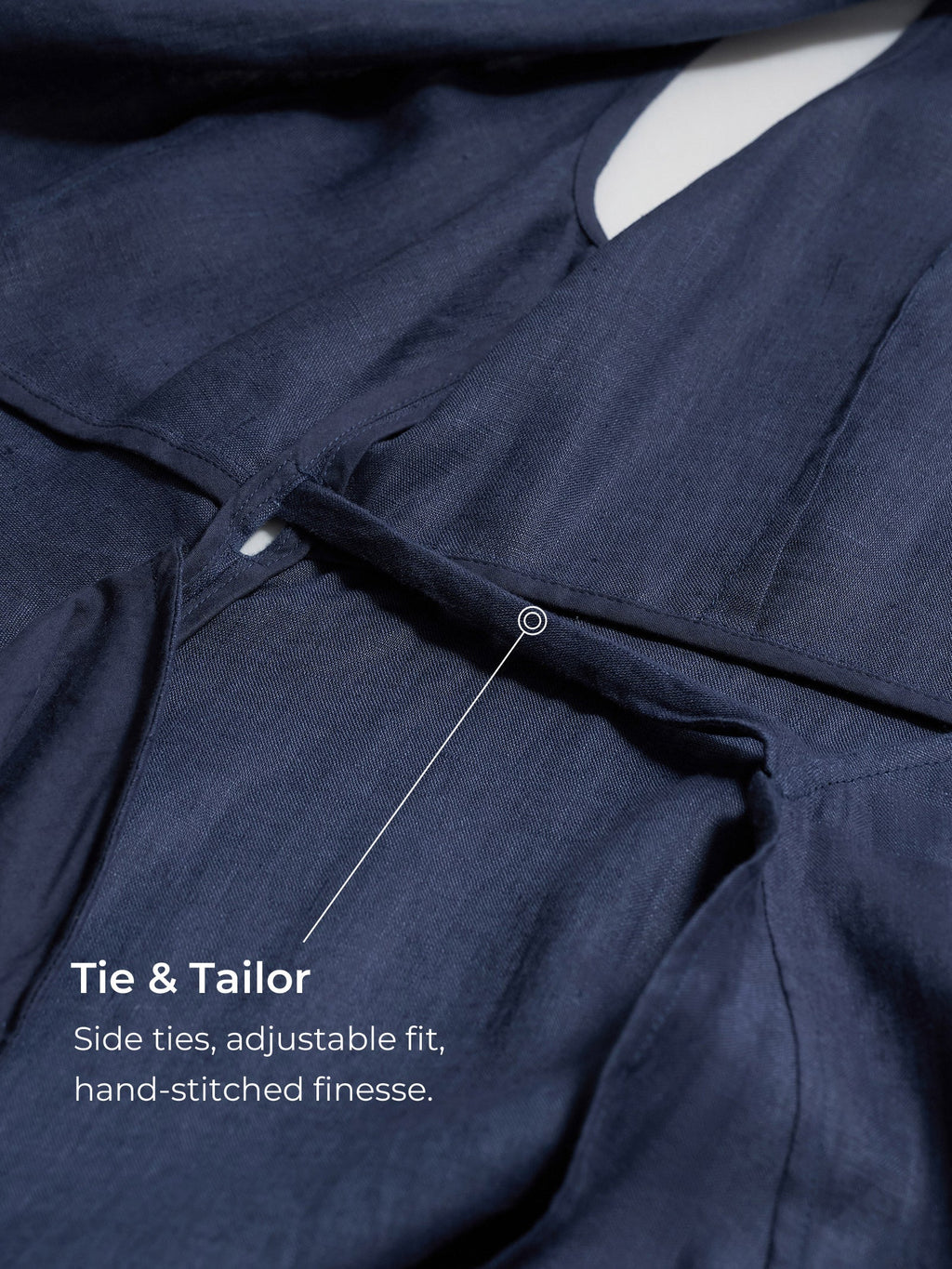 Navy blue garment with side tie feature and text indicating 'Tie & Tailor' brand.