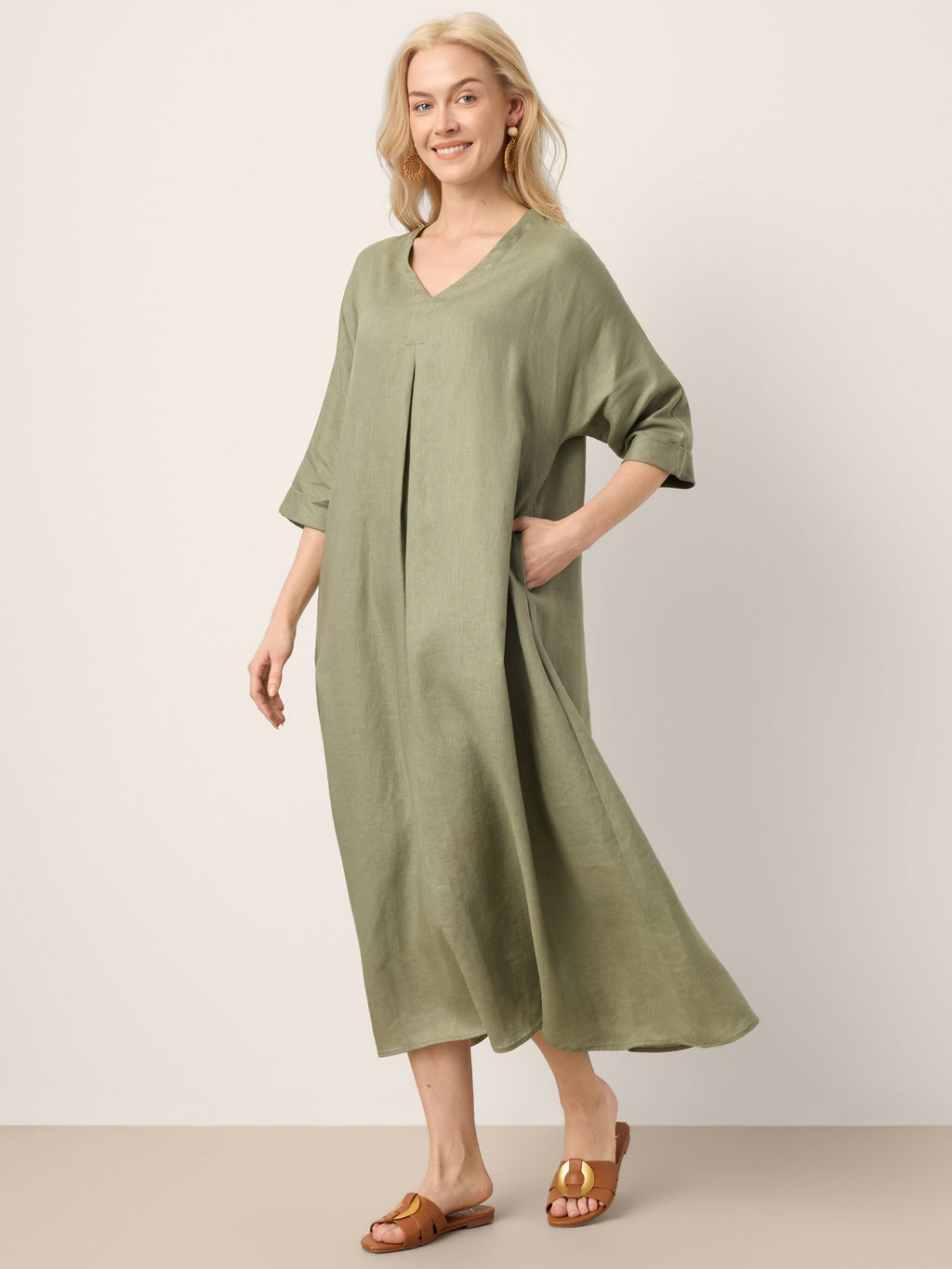 Woman wearing a green dress against a plain background