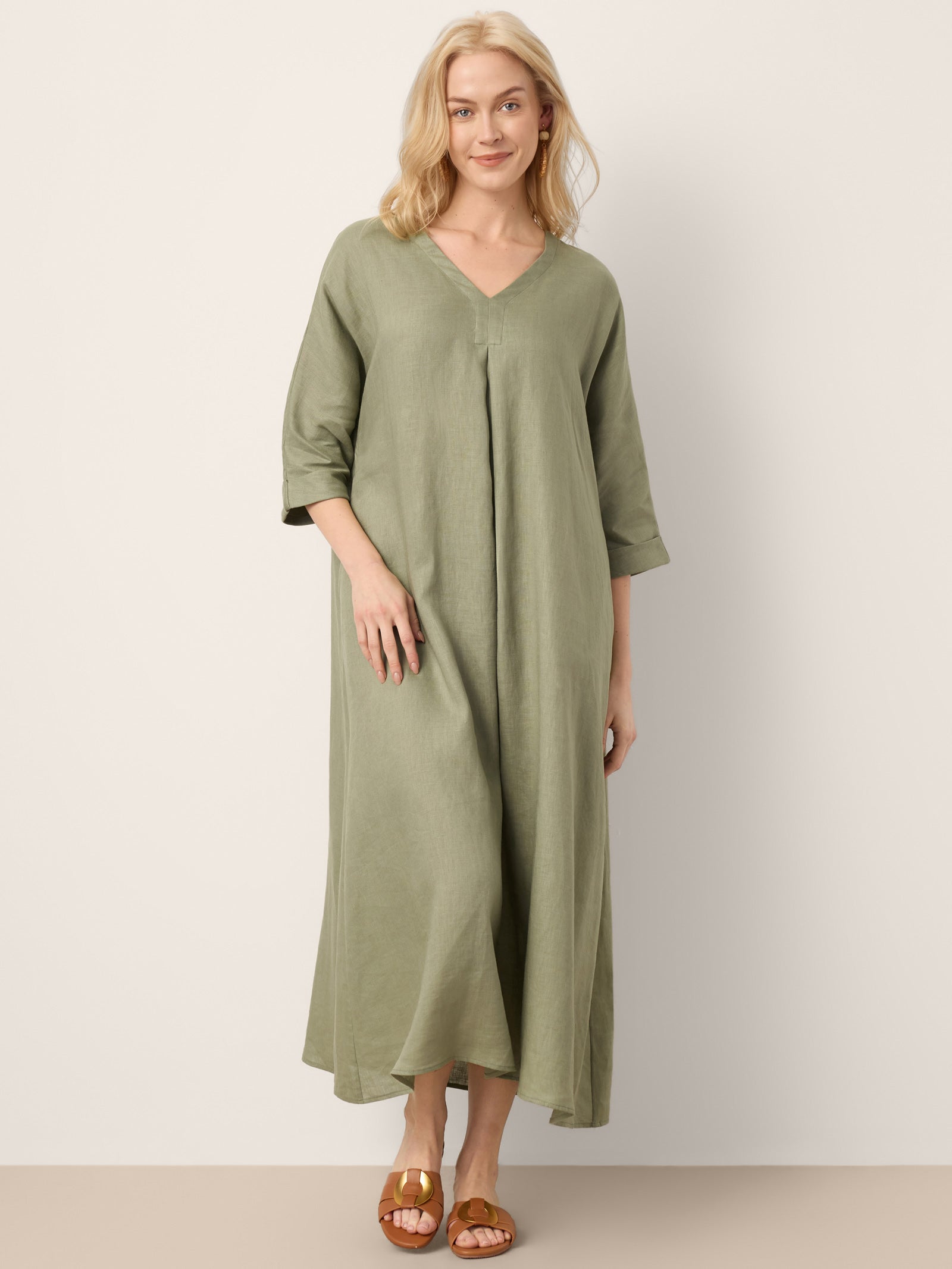 Woman wearing a green dress against a plain background