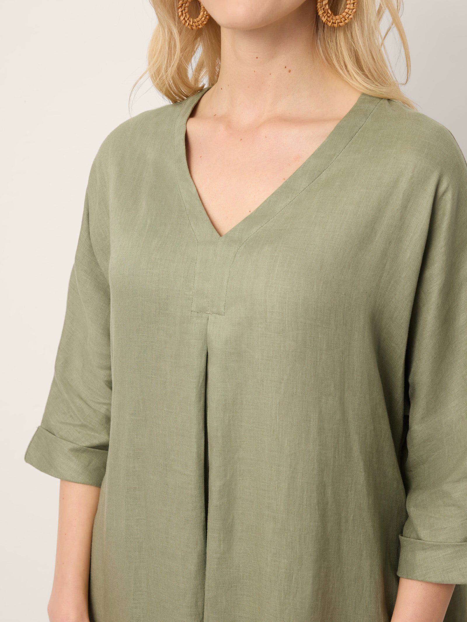 Person wearing a green dress with a plain background