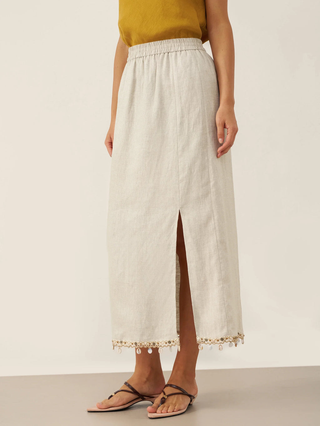 Woman wearing a white lace-trimmed skirt on a plain background