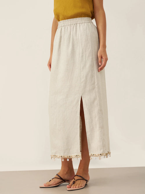 Woman wearing a white lace-trimmed skirt on a plain background