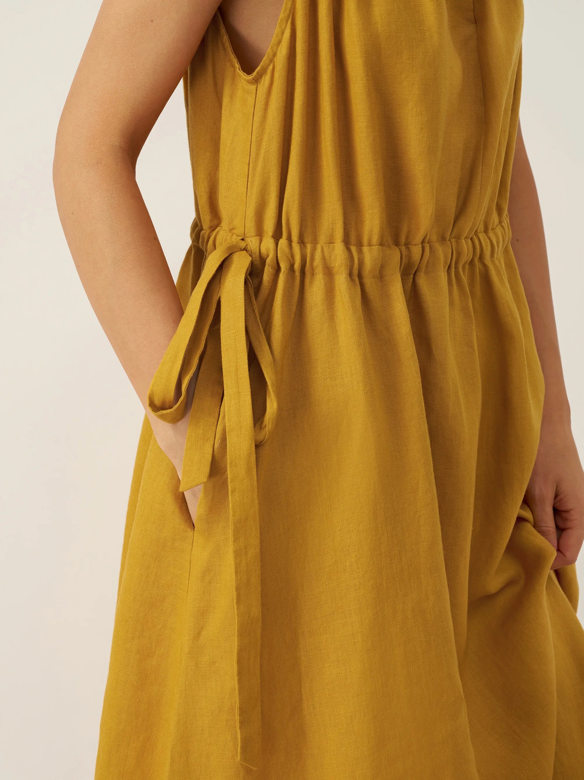 Yellow dress with a tie waist on a plain background