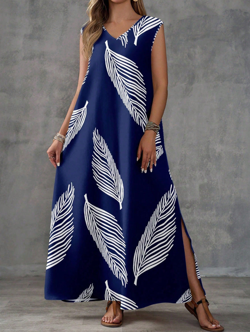 Woman wearing a navy blue dress with white leaf patterns against a gray background