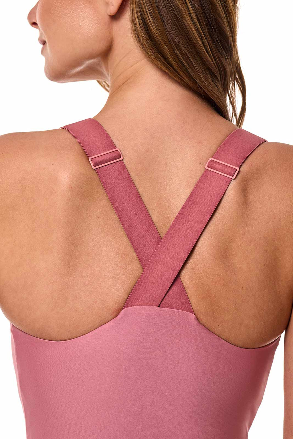 Pink swimsuit with criss-cross straps on a white background