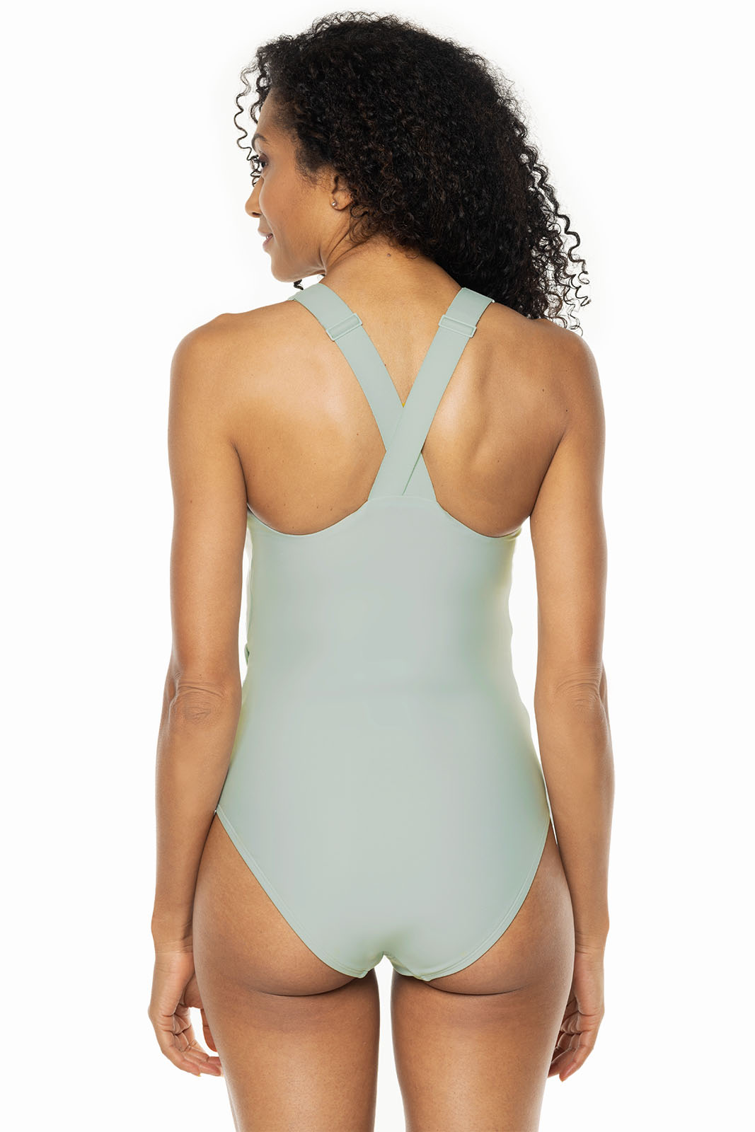 Woman wearing a light green one-piece swimsuit on a white background
