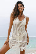 Woman wearing a white crochet dress on a beach