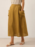 Person wearing a mustard yellow linen skirt with a plain background