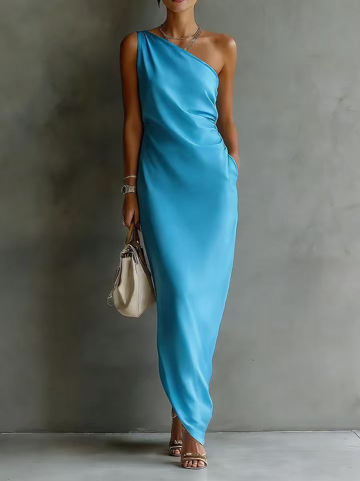 Woman wearing a blue one-shoulder dress against a gray background