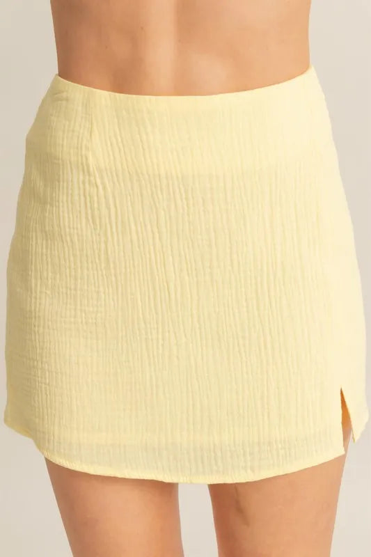 Yellow skirt worn by a person on a plain background