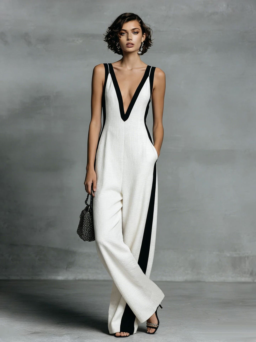 Woman wearing a white and black dress against a gray background