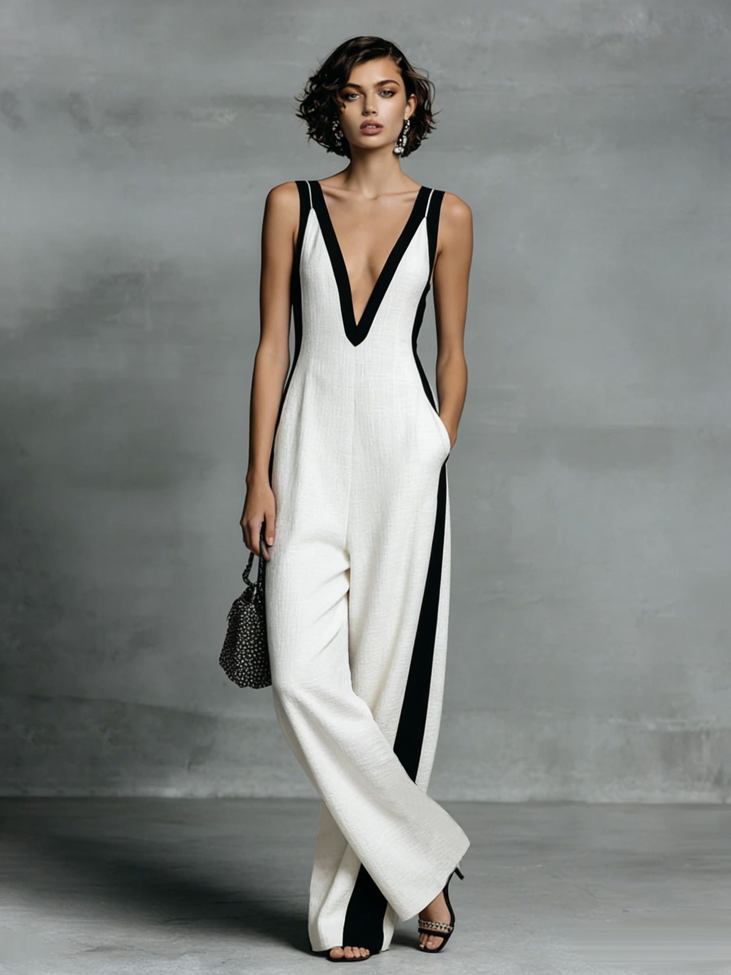 Woman wearing a white and black dress against a gray background