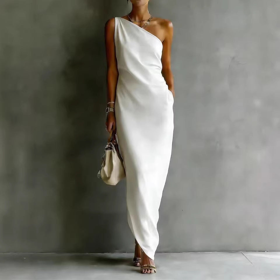 Woman wearing a white one-shoulder dress against a gray background