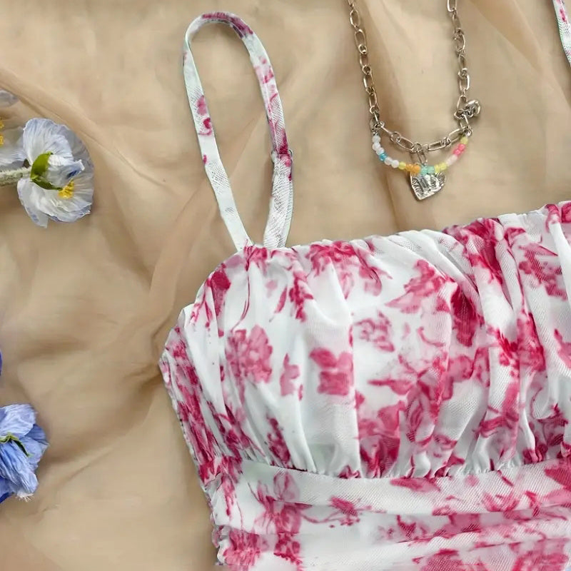 Red and white floral dress with accessories on a beige surface