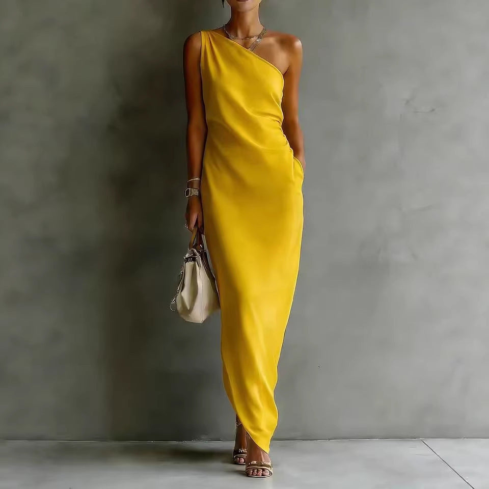 Woman wearing a yellow one-shoulder dress against a gray background