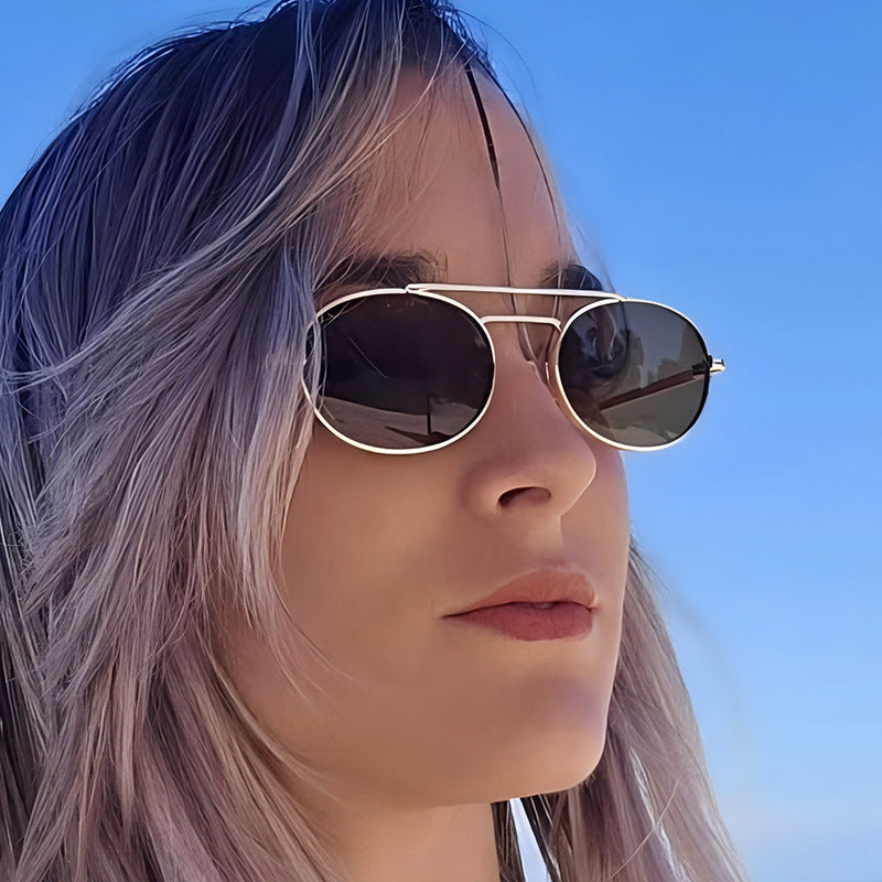 Person wearing sunglasses with a clear blue sky background