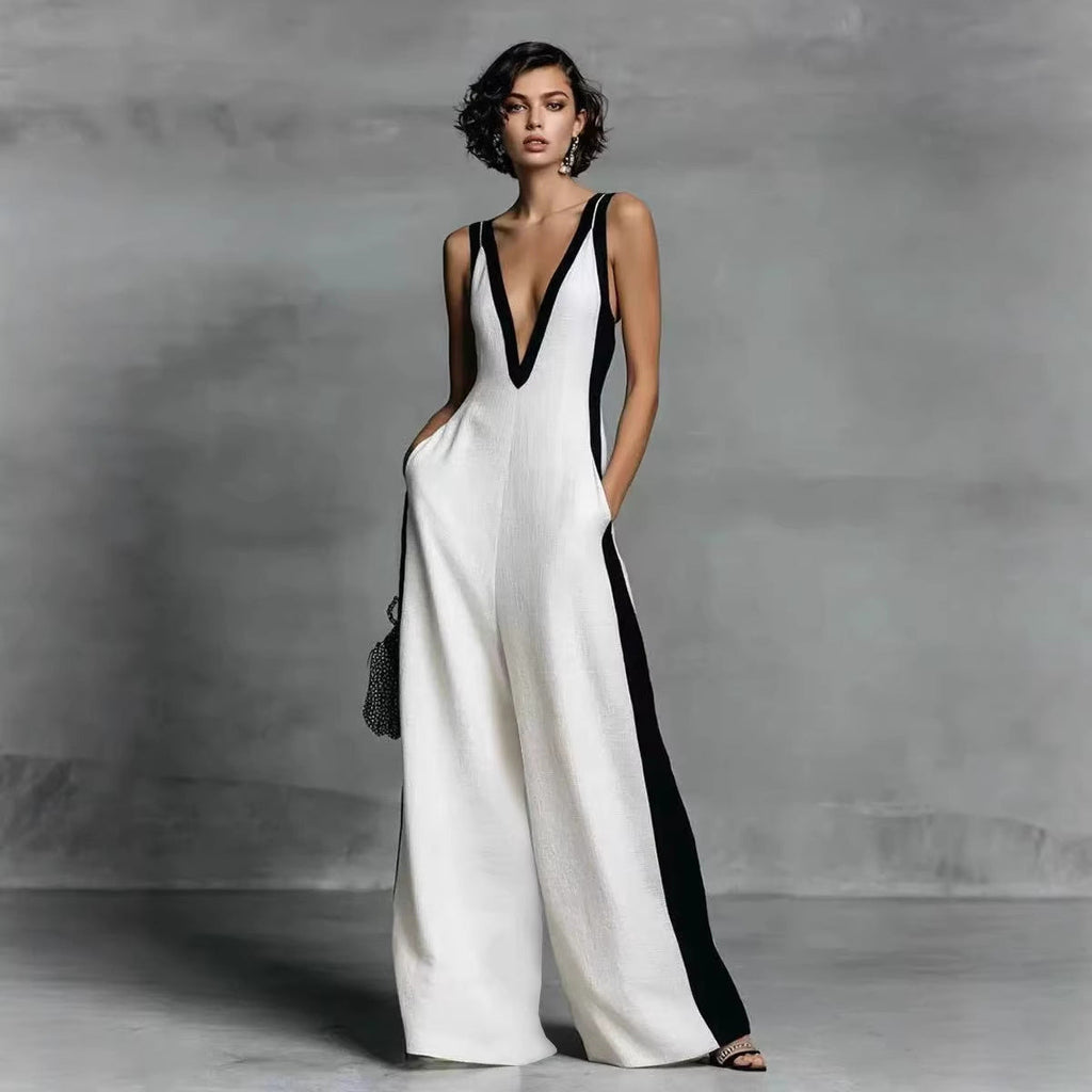 Woman wearing a white and black jumpsuit against a gray background
