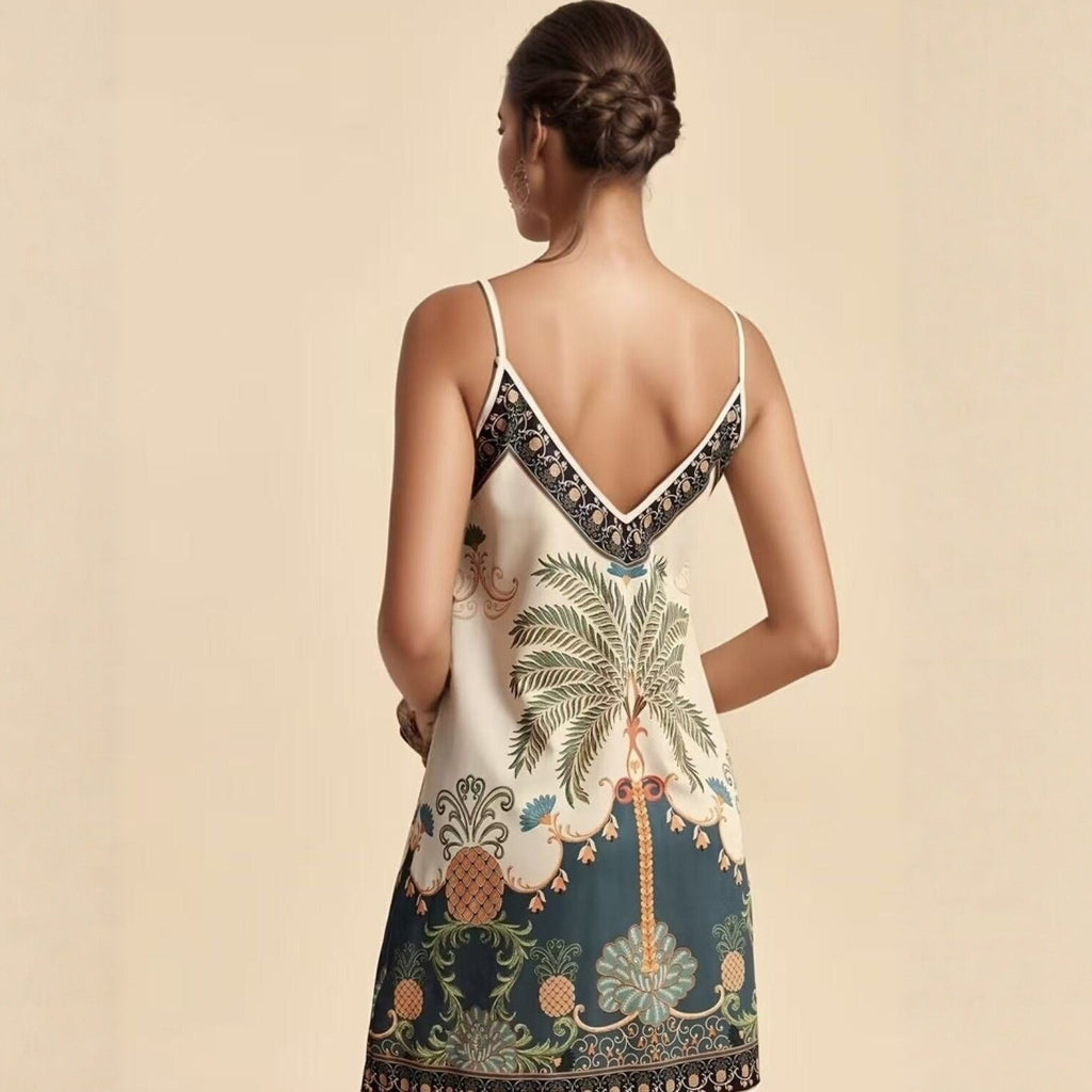 Woman wearing a dress with a palm tree and pineapple design on a beige background