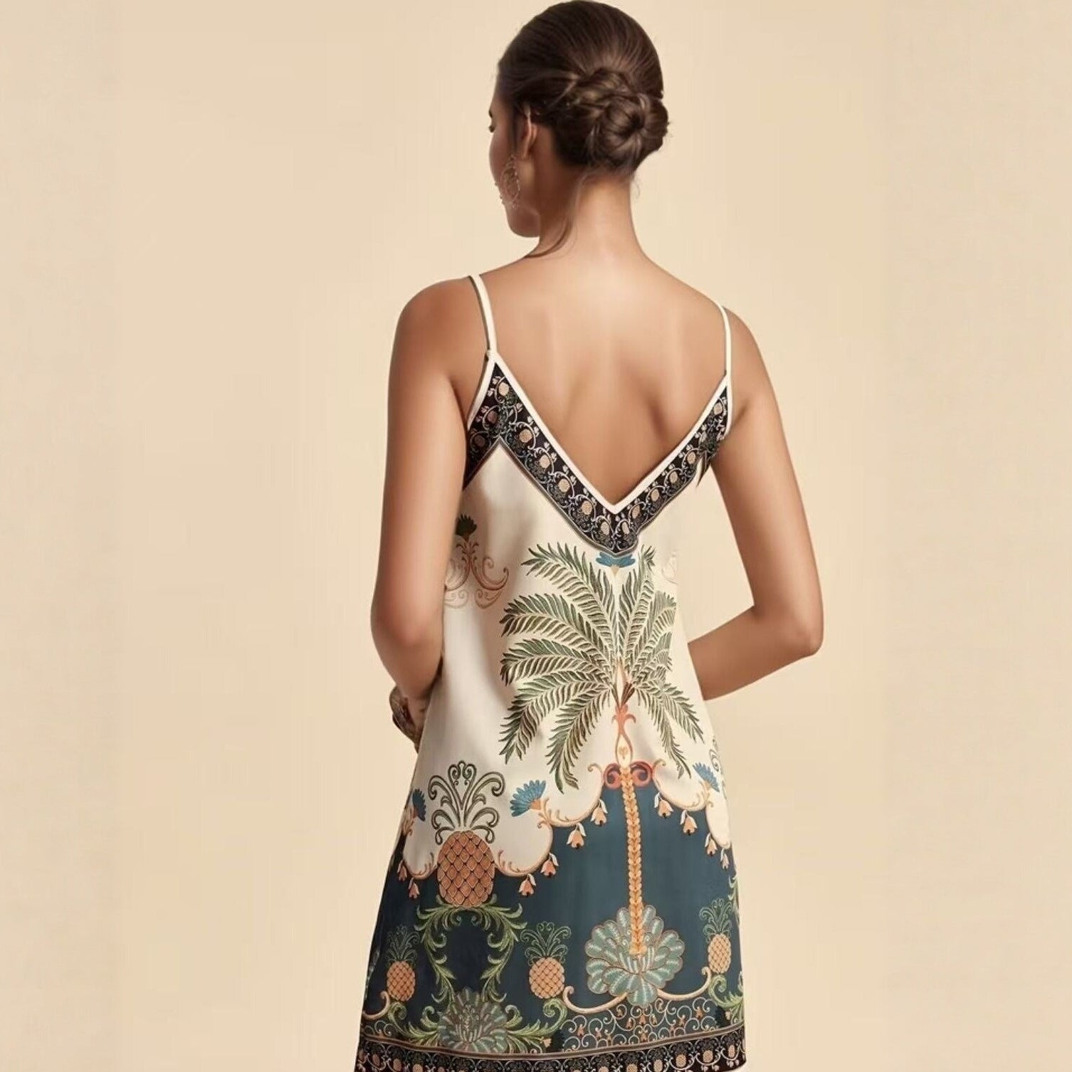Woman wearing a dress with a palm tree and pineapple design on a beige background