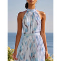 Woman wearing a blue floral dress with a blue sky and ocean background