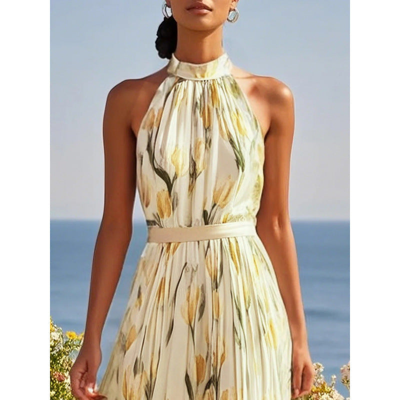 Woman wearing a yellow floral dress with a blurred ocean background