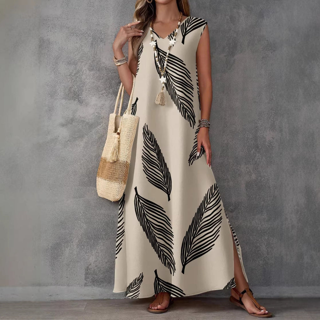 Woman wearing a long dress with black leaf pattern against a gray background