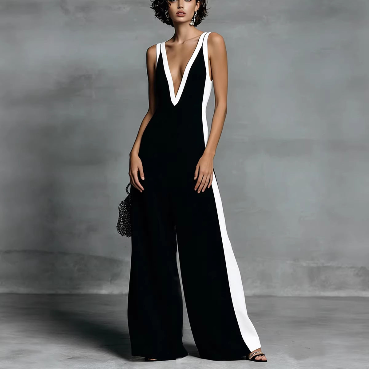 Woman wearing a black and white jumpsuit against a gray background