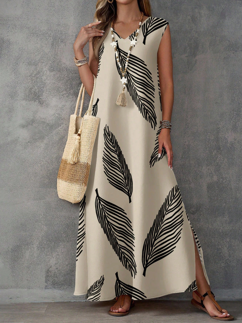 Woman wearing a long white dress with black leaf pattern holding a straw bag against a gray background