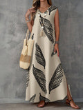 Woman wearing a long white dress with black leaf pattern holding a straw bag against a gray background