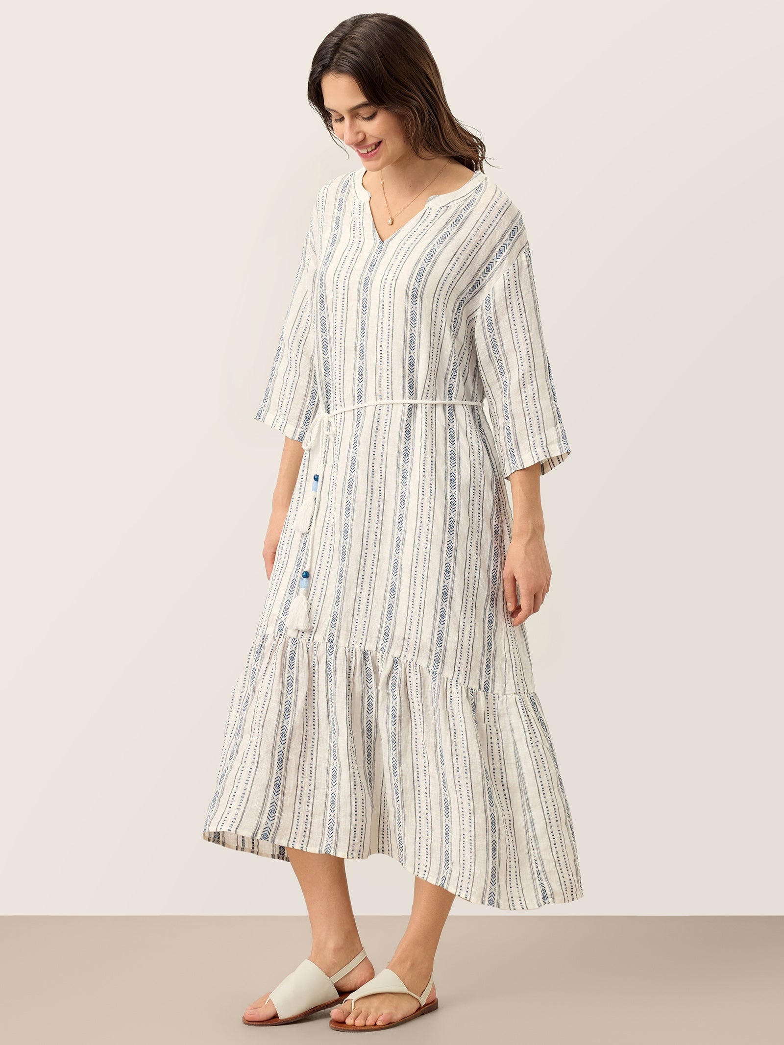 Woman wearing a striped dress on a plain background