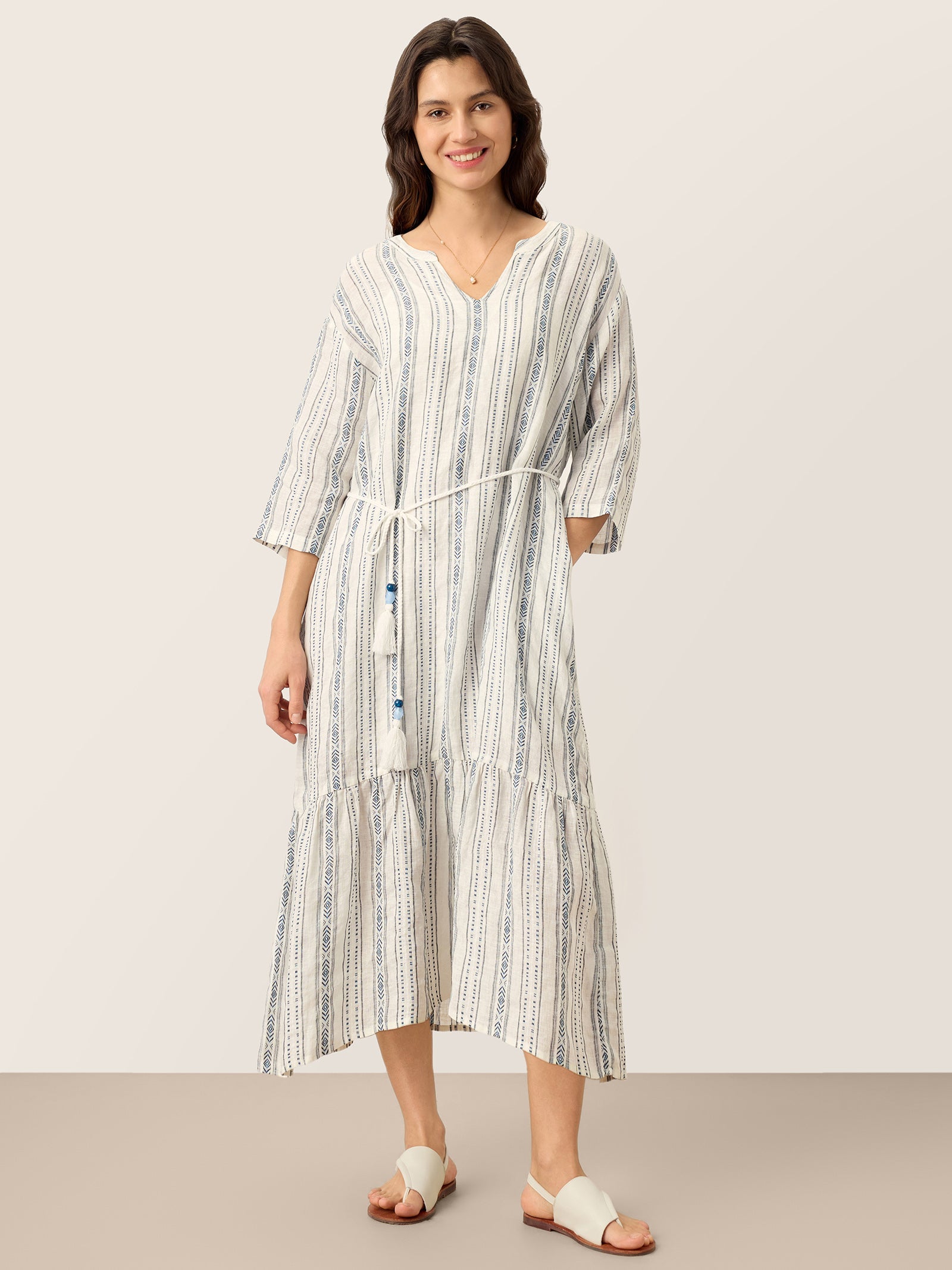 Woman wearing a striped dress on a plain background