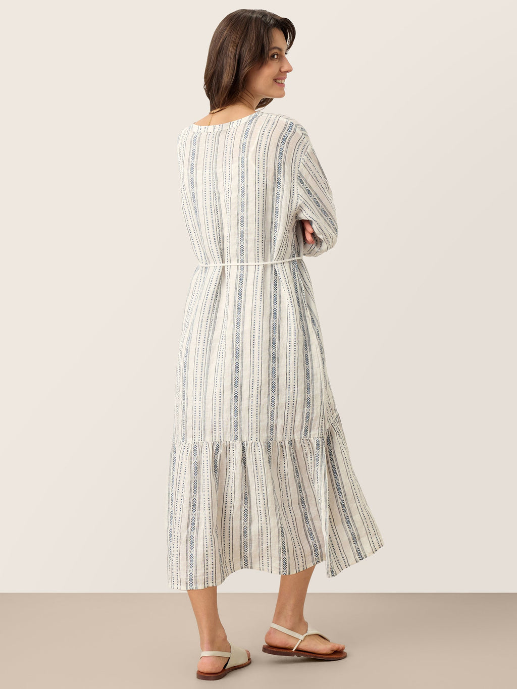 Woman wearing a striped dress against a plain background
