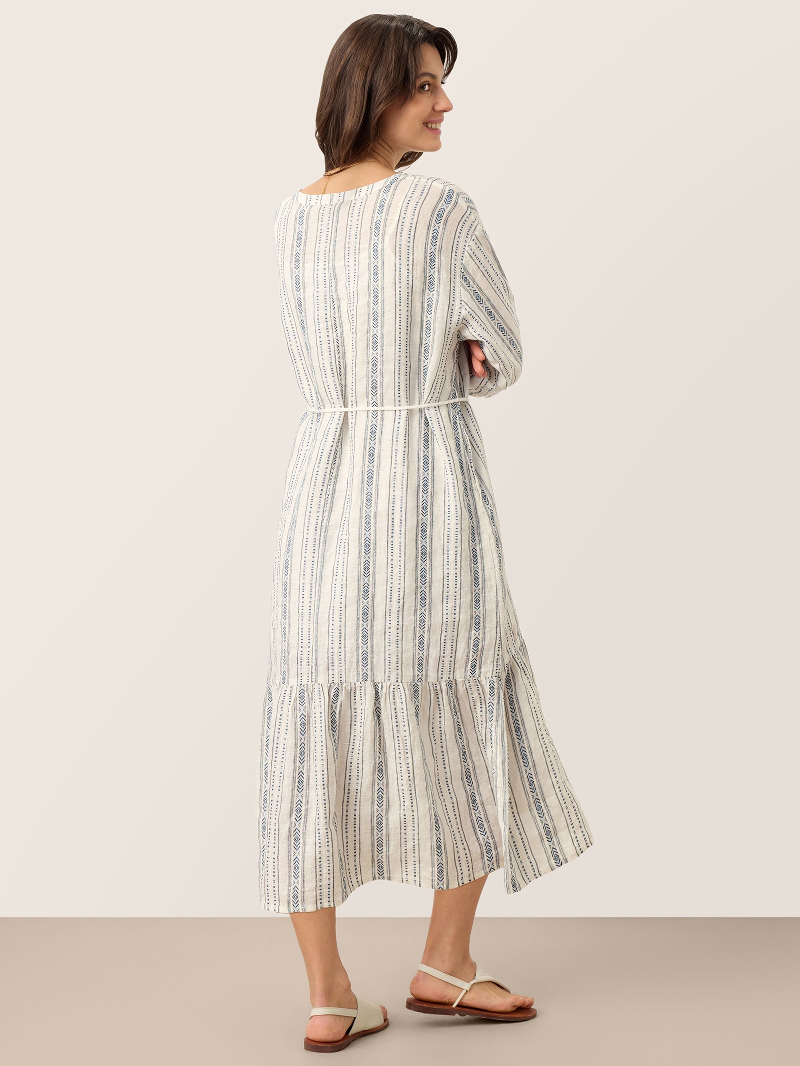 Woman wearing a striped dress against a plain background