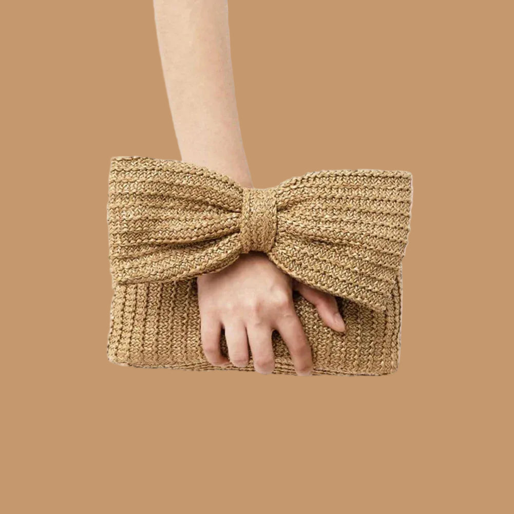 Person holding a woven clutch bag against a plain background