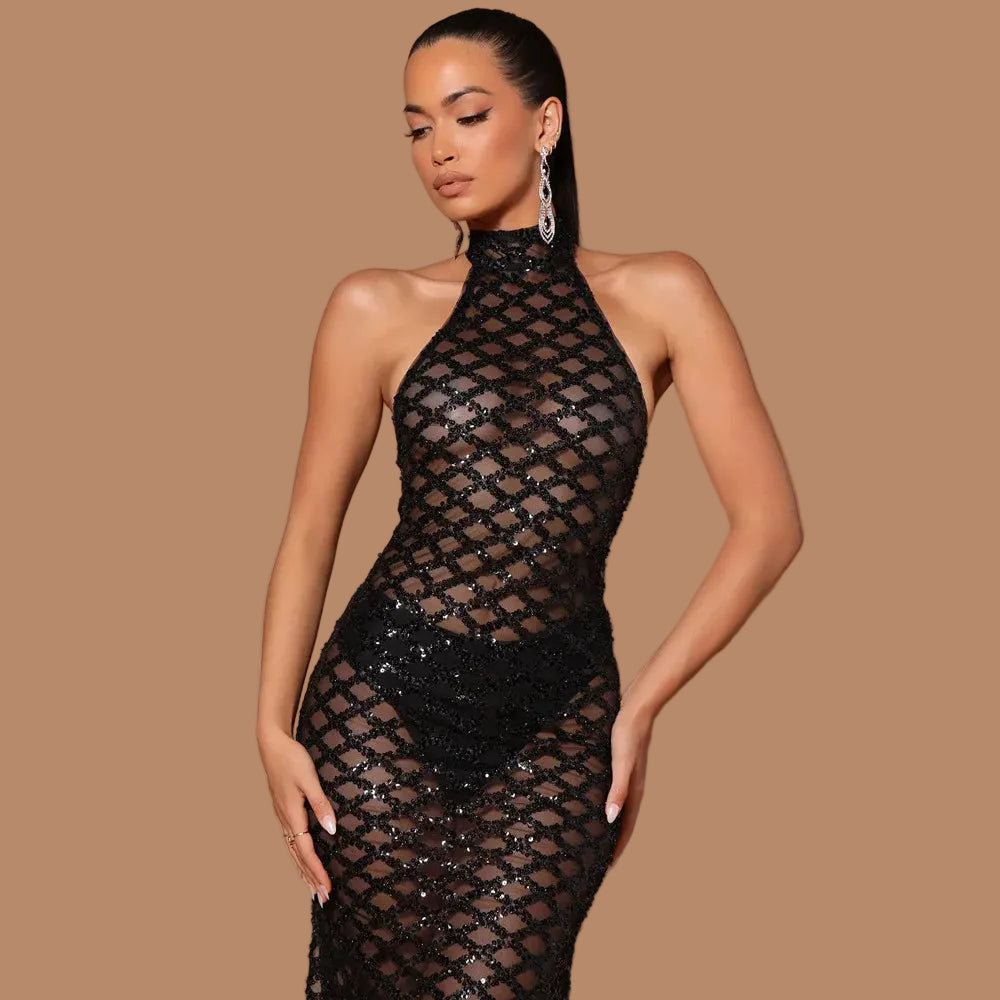 Woman wearing a black fishnet dress with sequins on a beige background