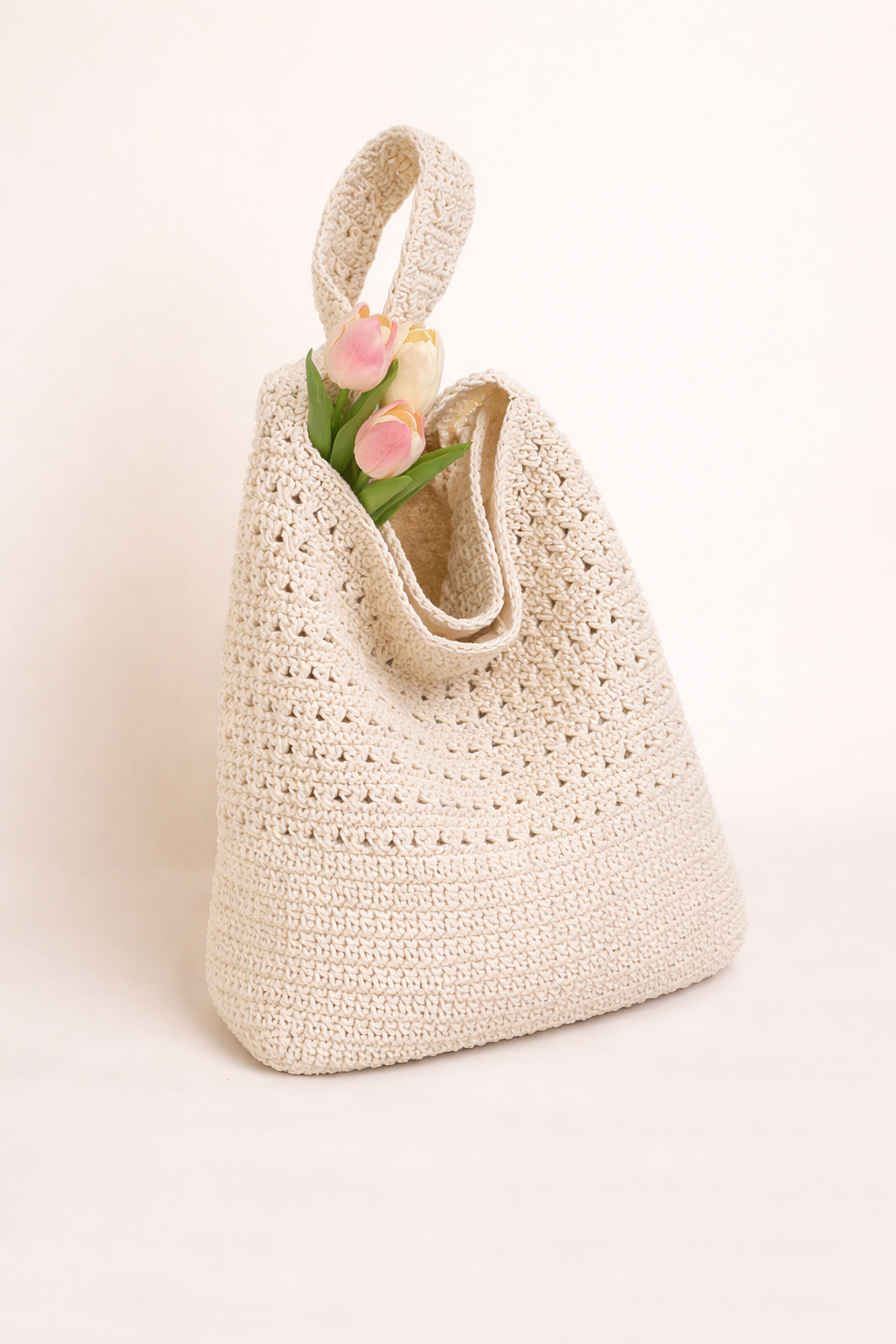 White crocheted bag with floral handle on a light background