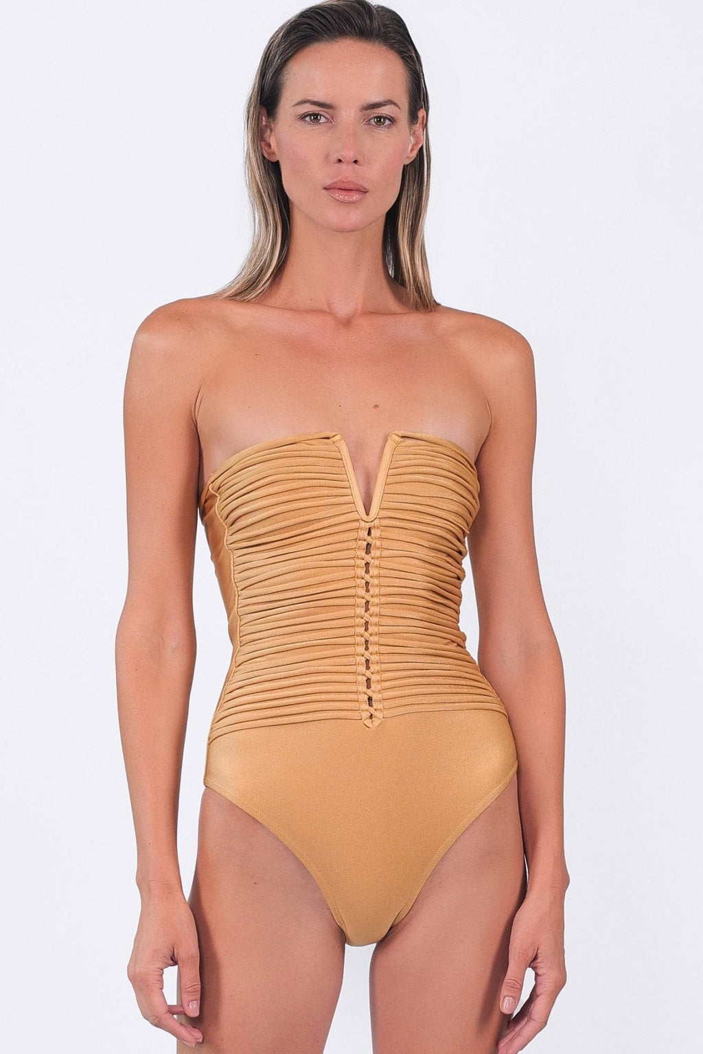 Woman wearing a mustard yellow strapless swimsuit on a white background