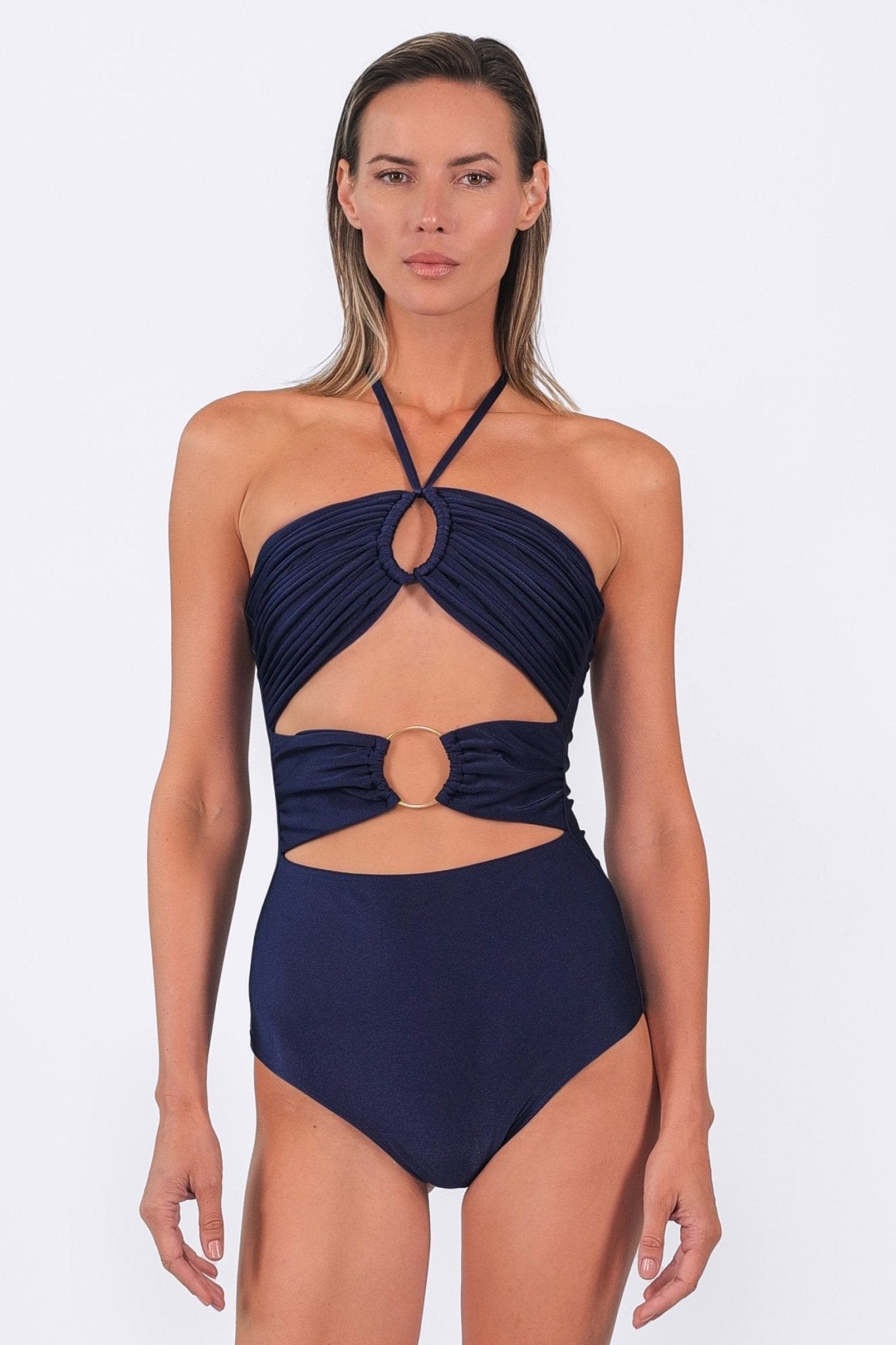 Woman wearing a navy blue halter neck swimsuit on a white background