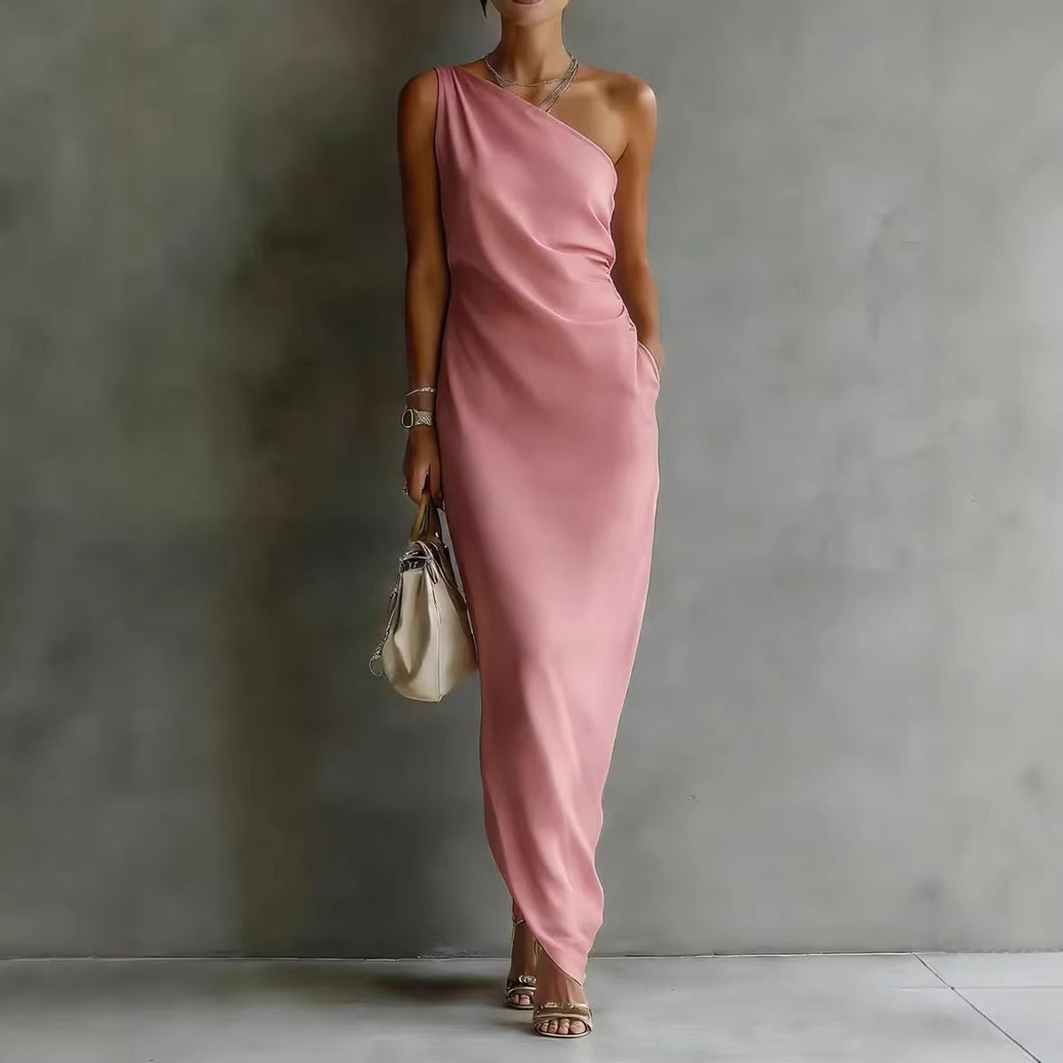 Woman wearing a pink one-shoulder dress against a gray background