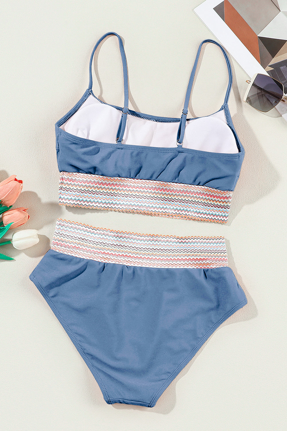 Blue and multicolor striped swimsuit on a white surface
