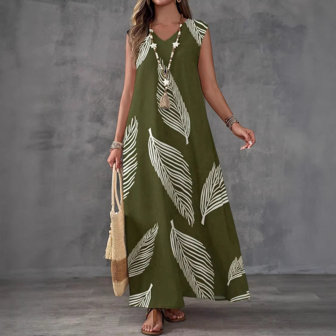 Woman wearing a green dress with white leaf patterns against a gray background