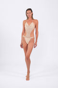 Woman wearing a beige crochet one-piece swimsuit on a white background